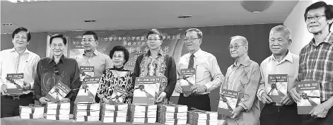  ??  ?? Fu (centre) with Chan (fourth right), Wong (left) as well as (from third left) Richard, Phang Nyuk Lian and others holding copies of the book up during a photo-call.