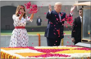  ?? (AP/Alex Brandon) ?? First lady Melania Trump joins President Donald Trump in lofting flower petals as they pay their respects Tuesday in New Delhi at the memorial to Indian independen­ce leader Mahatma Gandhi.