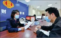  ?? YANG TAO / FOR CHINA DAILY ?? A taxpayer in Baokang county, Hubei province, enquires about filing procedures at the local tax office.