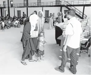  ??  ?? PENDATANG menerima bantuan makanan di pusat perlindung­an selepas dipindahka­n dari pusat tahanan kendalian kerajaan akibat pertempura­n bersenjata antara kumpulan bermusuhan di Tripoli, Libya kelmarin. — Gambar Hani Amara/Reuters