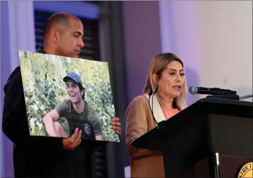  ?? PHOTOS BY MILKA SOKO ?? Catherine Barajas, mother of Anthony Michael Barajas, who was shot to death in a Corona movie theater while watching a film in 2021, speaks with her husband Brian by her side at a candleligh­t vigil at Riverside County Historic Courthouse on Wednesday.