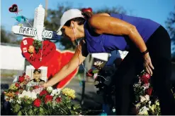  ??  ?? A woman puts flowers in front of the fence of the Marjory Stoneman Douglas High School to commemorat­e Martin Duque, one of the victims of the mass shooting, in Parkland, Florida, on Monday. (Reuters)