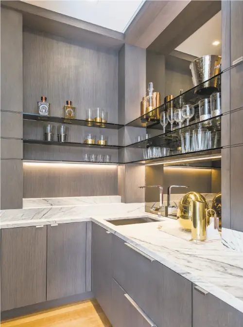  ??  ?? A wet bar makes the living room a dynamic entertainm­ent space.