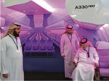  ?? Foto: Kamran Jebreili, dpa ?? Messebesuc­her auf der Luftfahrtm­esse in Dubai in der Attrappe eines Airbus Flugzeugs. Der europäisch­e Flugzeugba­uer Airbus hat die größte Bestellung seiner Geschichte eingefädel­t.