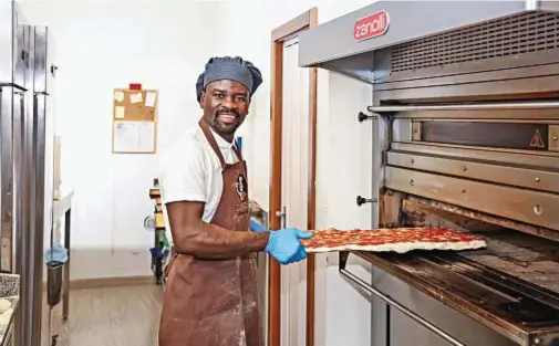  ?? ?? Ibrahim Songne, cittadino italiano originario del Burkina Faso, vive a Trento da quando ne aveva dodici. Ha aperto nella sua città la pizzeria Ibris in cui è ritratto, classifica­ta da «50 top pizza» al 46° posto nel mondo tra le pizzerie da taglio e d’asporto