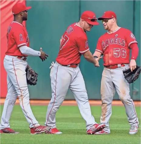  ?? KELLEY L. COX, USA TODAY SPORTS ?? Mike Trout, center, and the Angels got offensive help in Justin Upton, left. “We never quit,” says outfielder Kole Calhoun, right.