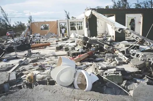  ??  ?? Une toilette se retrouve dans les débris de la maison de George Bolter détruite par l’ouragan Dorian dans le quartier de Pine Bay à Freeport, aux Bahamas. - Associated Press: Ramon Espinosa
