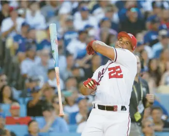  ?? GINA FERAZZI/LOS ANGELES TIMES ?? The Nationals’ Juan Soto flips his bat after advancing to the second round of the Home Run Derby on Monday night at Dodger Stadium. Soto went on to win the Derby, besting Mariners rookie Julio Rodríguez in the finals.