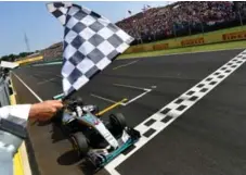  ?? ANDREJ ISAKOVIC/AFP/GETTY IMAGES ?? Lewis Hamilton crosses the finish line to win the Formula One Hungarian Grand Prix at the Hungarorin­g circuit in Mogyorod on Sunday.