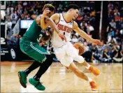  ?? ASSOCIATED PRESS ?? PHOENIX SUNS GUARD Devin Booker (1) is fouled by Boston Celtics guard Marcus Smart during the second half of a game Thursday in Phoenix.