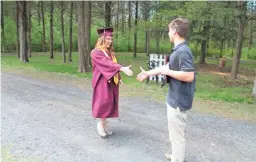  ??  ?? Gabrielle Bancroft receives a diploma from her brother during an impromptu graduation ceremony in her parents’ driveway to celebrate her Arizona State University degree. COURTESY OF GABRIELLE BANCROFT