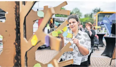  ?? FOTO: STEPHAN KÖHLEN ?? Erstmals gab es einen sogenannte­n Demokratie­baum auf dem Erkrather Feierabend­markt: Luana verziert ihn mit ihren Wünschen auf einem Post-It.