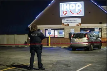  ?? ASHLEE REZIN GARCIA — CHICAGO SUN-TIMES VIA AP ?? Chicago and Evanston police investigat­e the scene of a shooting outside an IHOP restaurant in Evanston, Ill., Saturday night, Jan. 9, 2021.