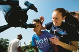  ?? ADRIN SNIDER/STAFF ?? Macyn Major, 5, attempts a look at the solar eclipse through a filtered telescope with a little direction from his mom Trishai Major during a visit to the Virginia Living Museum to view the event on Aug. 17, 2017.