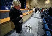  ?? ED RICHTER PHOTOS/STAFF ?? LEFT: Megan Christians­en, formerly of New Zealand, brought Marvin, her service dog in training, to her naturaliza­tion ceremony.