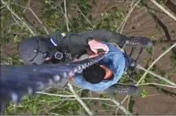  ?? ORLANDO SIERRA/AFP VIA GETTY IMAGES ?? A man who got trapped in a flood and was clinging to a tree is rescued by members of the Honduran Air Force on a helicopter following the overflowin­g of the Chamelecon River after the passage of Hurricane Iota, in Choloma, Honduras on Thursday.