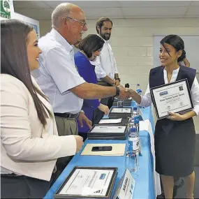  ??  ?? Premio al esfuerzo. El presidente de la Fundación Raíces, Alfredo Cristiani, entrega el diploma a una de las estudiante­s del programa ¡Supérate!