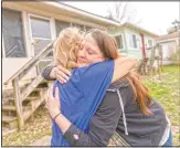  ??  ?? Sarah Kelly (right) is embraced by Sue Howland with the Quick Response Team after Howland presented her with a coin marking Kelly’s one-year anniversar­y in recovery outside her home in Guyandotte, W.Va.