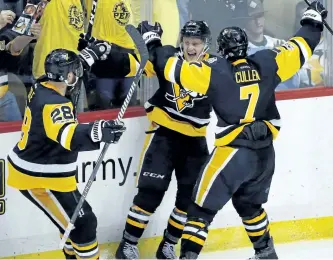  ?? GENE J. PUSKAR/THE ASSOCIATED PRESS ?? Pittsburgh Penguins’ Jake Guentzel, centre, celebrates his goal against the Nashville Predators with Ian Cole, left, and Matt Cullen during the third period in Game 1 of the NHL hockey Stanley Cup Finals, on Monday in Pittsburgh.