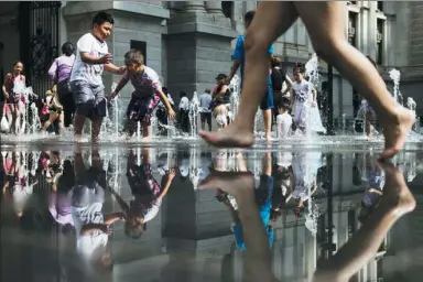  ?? MATT ROURKE / ASSOCIATED PRESS ?? People cool off in a fountain at Dilworth Park in Center City, Pennsylvan­ia, on Friday. The US National Weather Service has issued an excessive heat warning for the area.