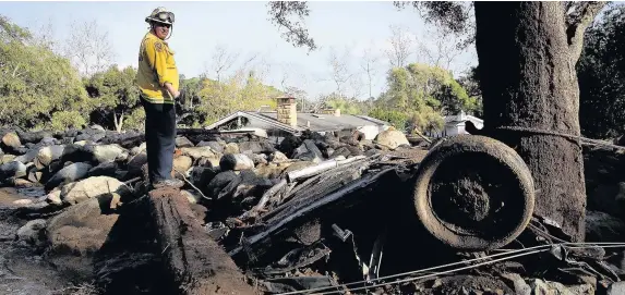  ?? Justin Sullivan ?? > A firefighte­r searches for people trapped in mudslide debris in Montecito, California