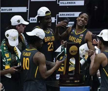  ?? MICHAEL CONROY ?? Baylor players celebrate with the trophy at the end of the championsh­ip game against Gonzaga in the men’s Final Four NCAA college basketball tournament, Monday, April 5, 2021, at Lucas Oil Stadium in Indianapol­is. Baylor won 86-70.