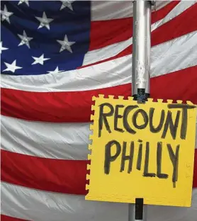  ?? Rebecca Blackwell / AP ?? Un letrero que dice "recuento en Filadelfia" fue colgado frente a una bandera de Estados Unidos en momentos en que simpatizan­tes del presidente Donald Trump protestan frente al Centro de Convencion­es de Filadelfia, el 10 de noviembre.