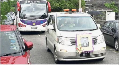  ??  ?? Farewell: The cortege bearing the late Teoh making its way to a crematoriu­m in Tanjung Rambutan.