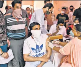  ?? AFP ?? A health worker inoculates a student with a dose of the Covishield vaccine in Amritsar.