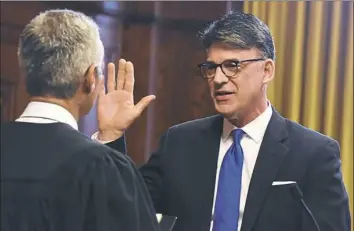  ??  ?? District Judge Gene Ricciardi administer­s the oath of office to Bruce Kraus, the sitting council president, who earned a rare third term in that role.