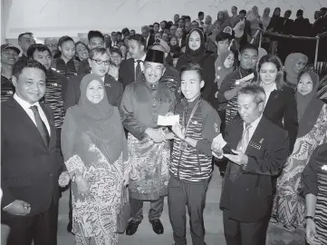  ??  ?? Musa with his wife Puan Sri Hajah Faridah Haji Tussin (second left) handing over the government’s incentive to one of the Sabah athletes who excelled at the recent Sea Games in Kuala Lumpur.