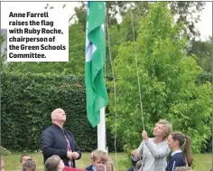  ??  ?? Anne Farrell raises the flag with Ruby Roche, chairperso­n of the Green Schools Committee.