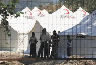  ?? Associated Press ?? Syrian refugees gather June 9 at a camp set up by the Turkish Red Crescent in Hatay province. Turkey is estimated to now host around 3.7 million refugees from the conflict in Syria.