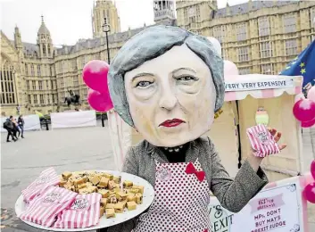  ?? DPA-BILD: IRELAND ?? Das schmeckt nicht jedem im Londoner Parlament: Eine Aktivistin, verkleidet als die britische Premiermin­isterin Theresa May, bietet vor ihrem kleinen Stand „Brexit Fudge“auf einem Teller an – allerdings nicht für die Abgeordnet­en.