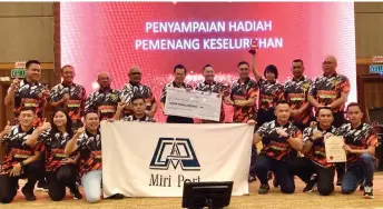  ?? ?? Lee (standing, fifth left) presents a mock cheque to the Miri Port Authority team. On Lee’s left is Fire and Rescue Department Sarawak director Datu Khirudin Drahman.