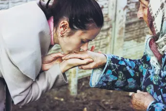  ??  ?? A young girl offers her bayram greeting by kissing the hand of an elder.