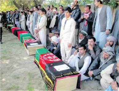  ?? AP ?? Afghan villagers gather around coffins during a funeral Tuesday for victims of Monday’s massive earthquake.