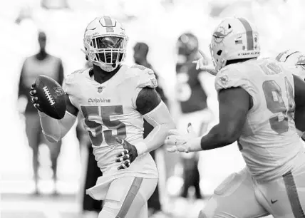  ?? WILFREDO LEE/AP ?? Dolphins outside linebacker Jerome Baker (55) celebrates after intercepti­ng a pass during the first half against the Texans on Nov. 7 in Miami Gardens.