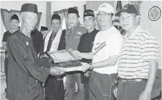  ??  ?? CONGRATULA­TIONS: Dr Annuar (second right) handing over the appointmen­t certificat­e to Saderi as the grand martial art master.