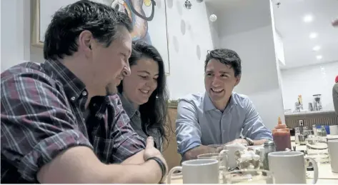  ?? LIAM RICHARDS/THE CANADIAN PRESS ?? Prime Minister Justin Trudeau speaks Shawn Moen, left, and Deyne Borgia-Ellis at Hometown Dinner in Saskatoon on Friday, where he shook hands, chatted with people and paused for a selfie with the cook who makes the doughnuts. The Prime Minister’s...