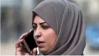  ?? AFP ?? Hajar Harb speaks on her mobile phone in front of the courts complex in Gaza City on Tuesday. —