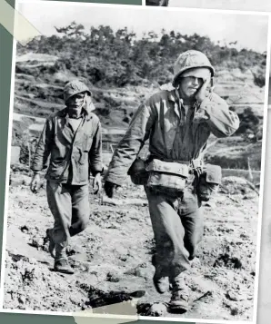  ??  ?? BELOW A US marine and a navy Hospital corpsman, both wounded in the Battle for Okinawa, but still 'walking cases', trudge towards a medical aid station for treatment. June 1945