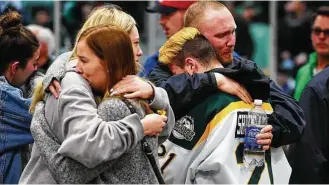  ?? Jonathan Hayward / Canadian Press via AP ?? Mourners comfort one anther at a vigil at the Elgar Petersen Arena, home of the Humboldt Broncos, to honor the victims of Friday night’s fatal bus crash in Humboldt, Saskatchew­an.