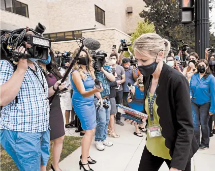  ?? MORRY GASH/AP ?? A spokeswoma­n walks from reporters after an extraditio­n hearing for Kyle Rittenhous­e on Friday at an Illinois court.