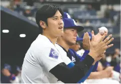  ?? CHUNG SUNG-JUN / GETTY IMAGES ?? Shohei Ohtani, who signed a US$700 million deal with the Los Angeles Dodgers in December, watches the action during Sunday’s exhibition game against
the Kiwoom Heroes in South Korea.