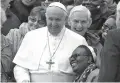  ?? ANDREW MEDICHINI/ASSOCIATED PRESS ?? Pope Francis shares a laugh Wednesday with a group of faithful as he poses for a family photo at the end of his weekly general audience in St. Peter’s Square at the Vatican.