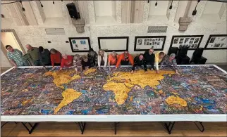  ?? WASHINGTON POST PHOTO ?? Springvill­e Senior Center members and puzzle artist Eric Dowdle, fifth from right, with the completed 60,000-piece puzzle earlier this month. The center is in Springvill­e, Utah.