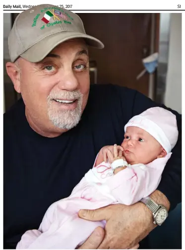  ??  ?? Practice makes perfect: Billy Joel cradles daughter Remy Anne, his third child