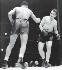  ?? CHICAGO TRIBUNE HISTORICAL PHOTO ?? Joe Louis, left, lands lefts and rights to the chin of King Levinsky as the Kingfish’s legs buckle on his way to the canvas on Aug. 7, 1935, in front of 39,195 fans at Comiskey Park.