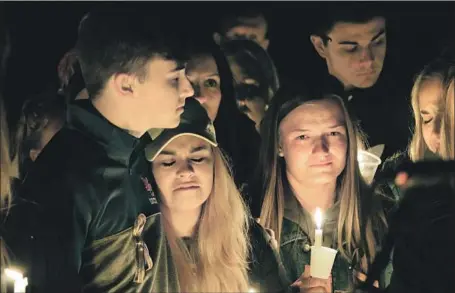  ?? Robert Ray Associated Press ?? PEOPLE ATTEND A VIGIL for the victims of a fatal shooting at a high school in Benton, Ky., this week. A 15-year-old boy is in custody.